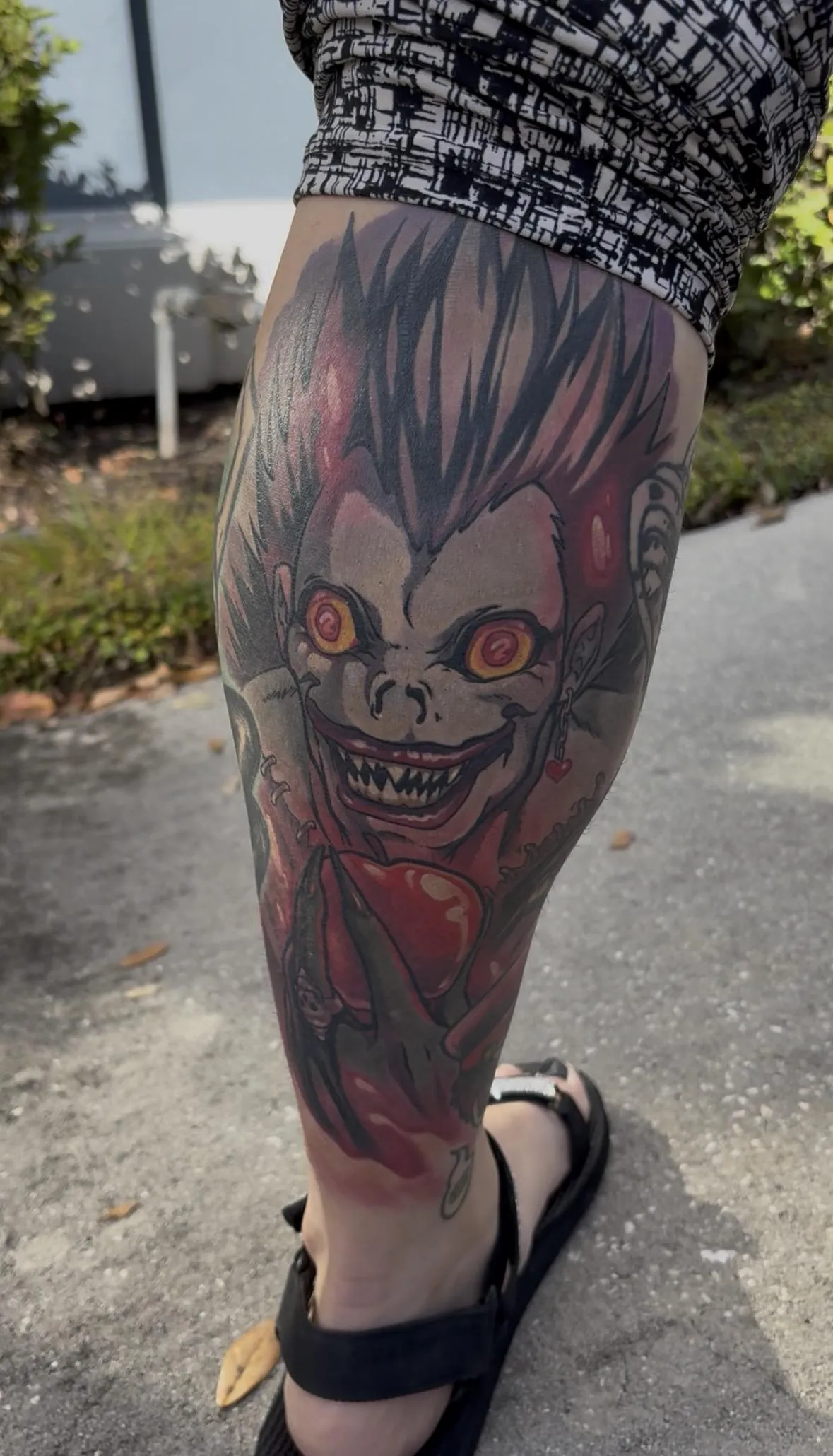 Fully healed anime tattoo of Ryuk from Death Note by Orlando Anime Tattoo Artist Ren Behan. This Ryuk tattoo features the bright red apple as a center point which draws the eye to Ryuk's menacing gaze.