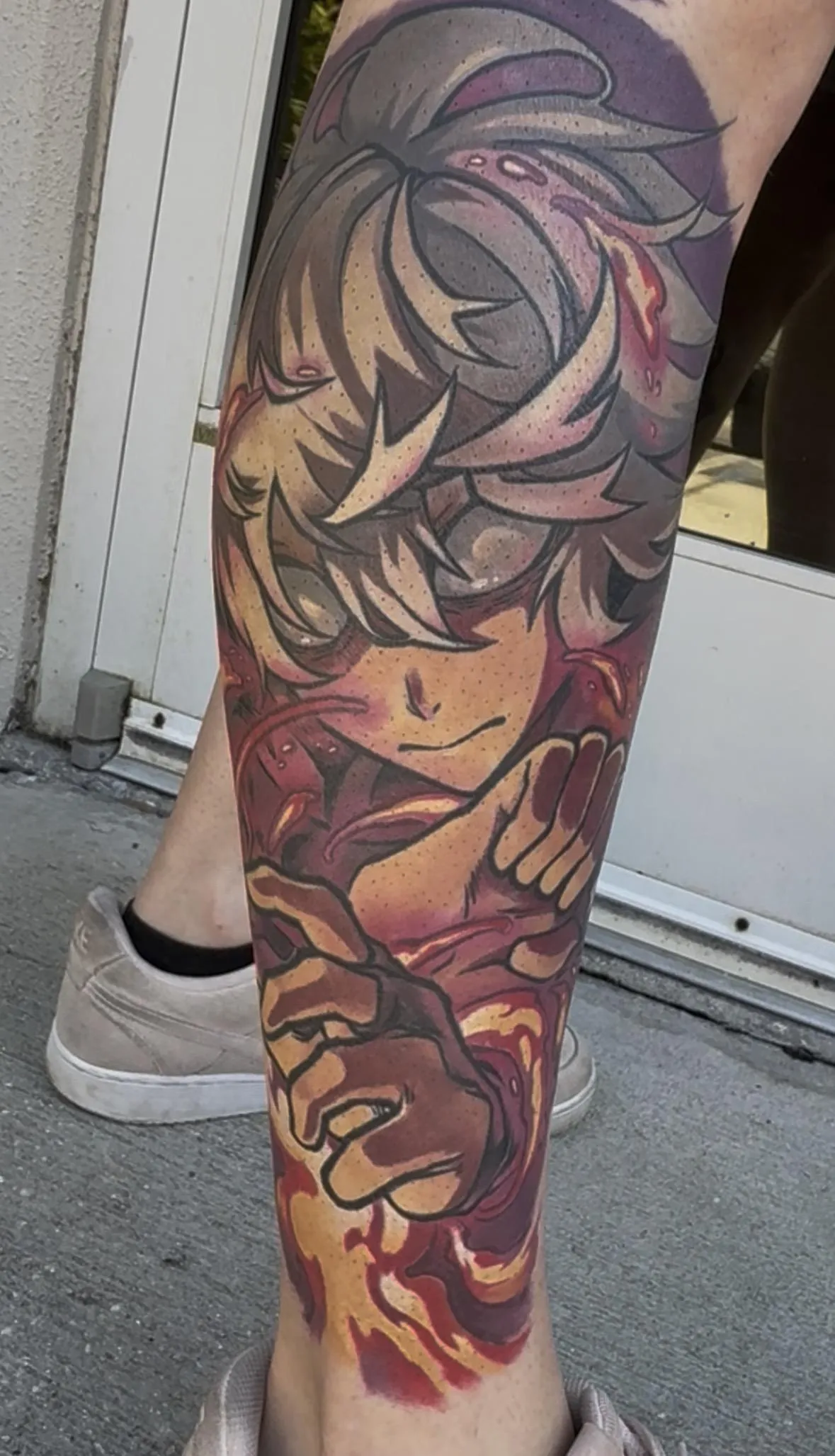 Fully healed anime tattoo of Gabimaru from Hell's Paradise by Orlando Anime Tattoo Artist Ren Behan. This Gabimaru tattoo is rich in contrast with bright pinks and yellows in his iconic fire attack.