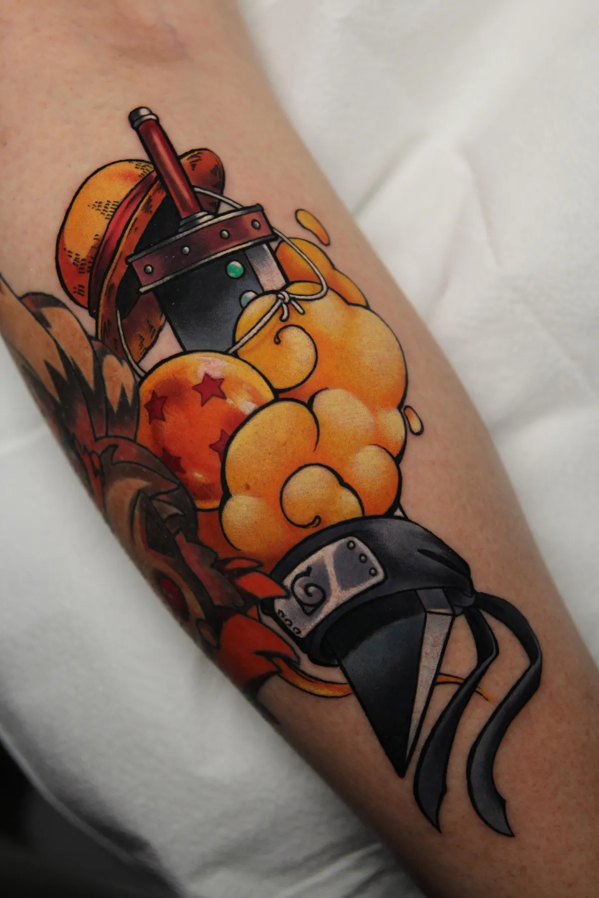 Anime symbol tattoo of Goku's nimbus, 4 star dragon ball, Cloud's buster sword, Luffy's straw hat, and Narutos headband by Orlando Anime Tattoo Artist Ren Behan.