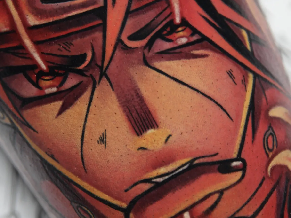 Anime tattoo of Itachi from Naruto by Orlando Anime Tattoo Artist Ren Behan. This Itachi tattoo features him doing the fire release attack using a vibrant monochromatic palette of reds and oranges.