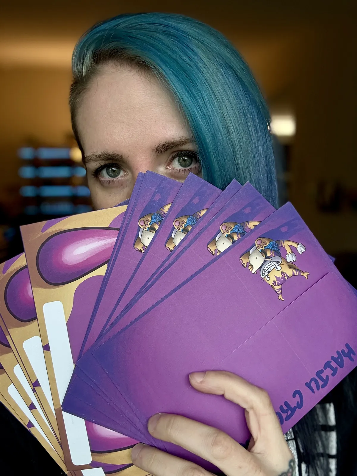 Image of tattoo artist Ren Behan holding up the special, colorful Kaiju Crushes envelopes for her Kaiju Crushes art mail club.