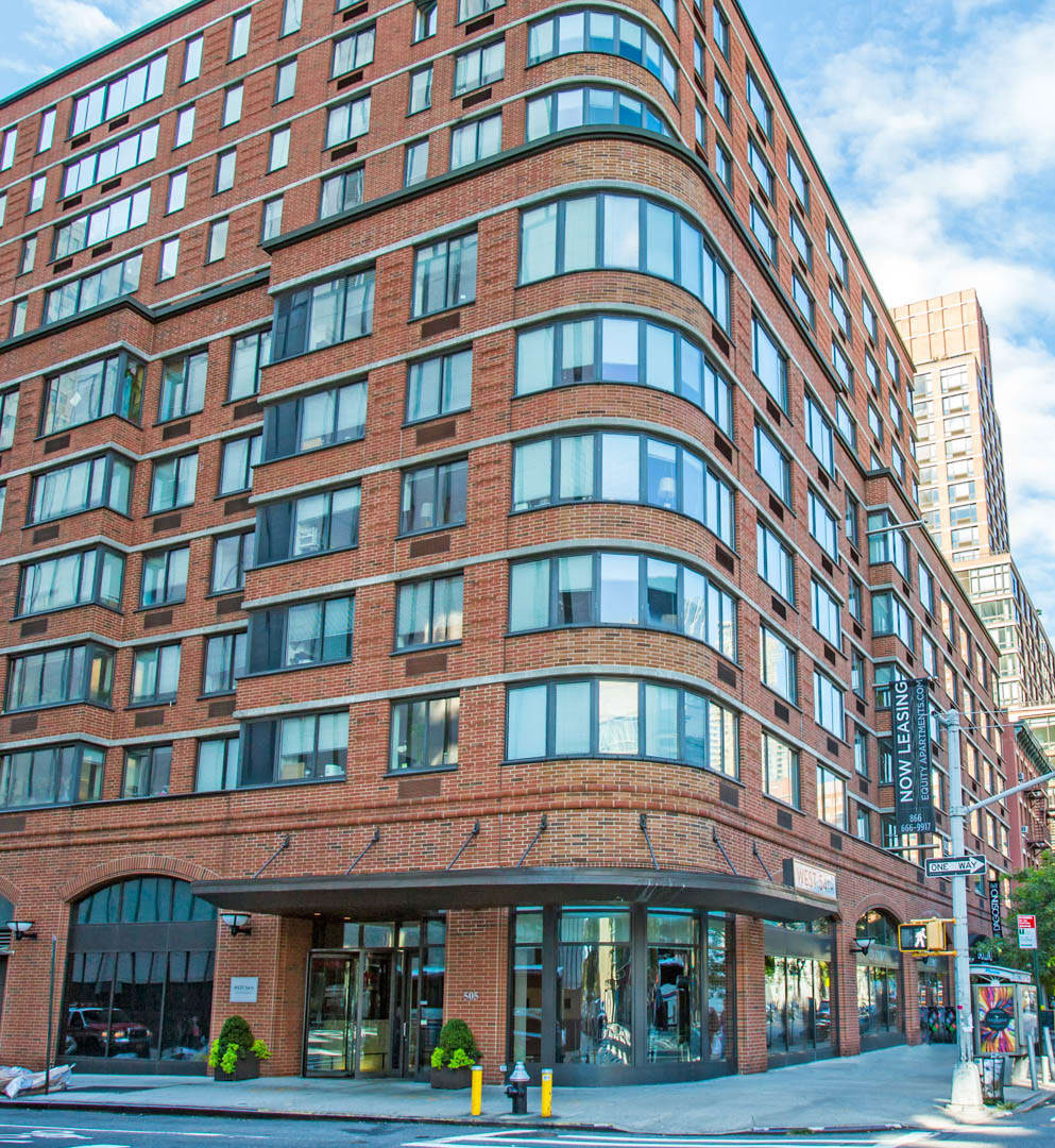 odern Manhattan galley kitchen remodel with white shaker cabinets, marble backsplash, wood herringbone floors, and high-end appliances by Home Design & Co.