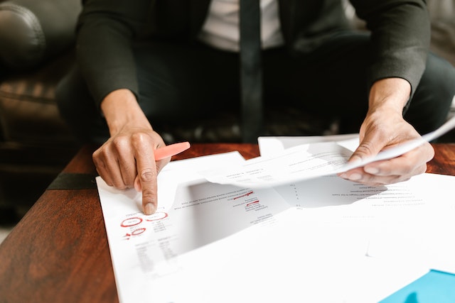 a person holding a pen over a piece of paper