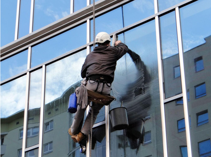 a person cleaning a building window