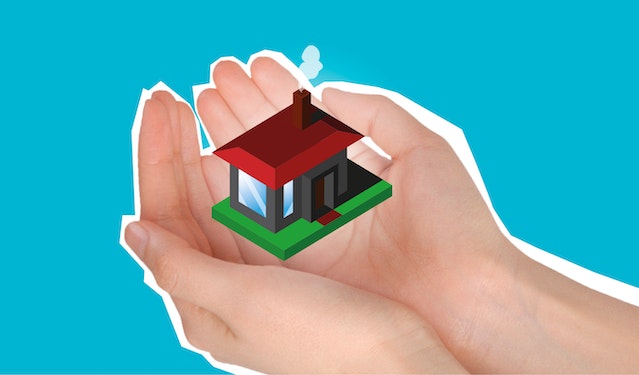 a person holding a small insured house