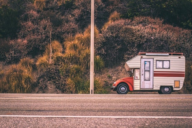 a red car with a camper on the side of the road