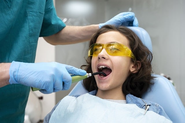 a person using a tool to check the teeth of a child