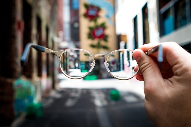 a hand holding a pair of glasses