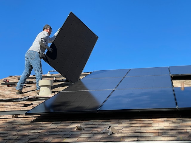a person installing solar panels on a roof