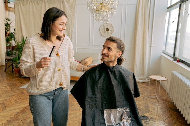 a person standing next to a person's haircut