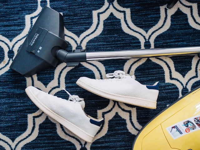 a vacuum cleaner and shoes on a carpet