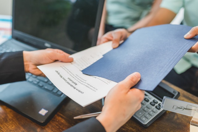 a person holding a blue mortgage envelope