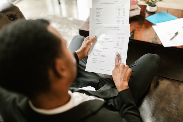 a person sitting on a couch holding a piece of paper