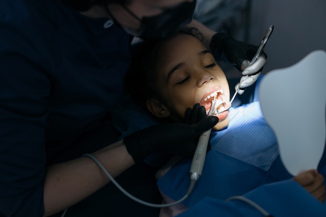 a dentist examining a child's teeth