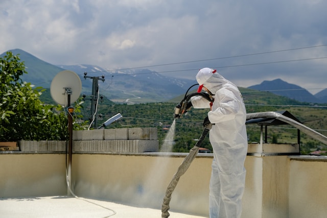 a person spraying a roof