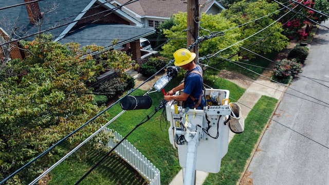 a person in a bucket working on power lines