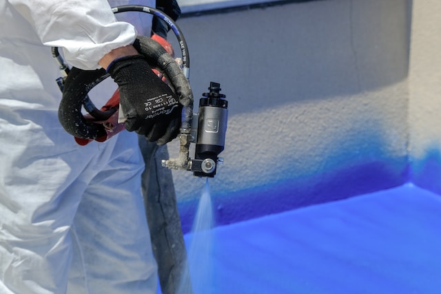 a person spraying a paint sprayer