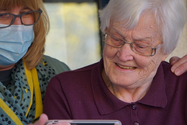 a older person looking at a cellphone with joy