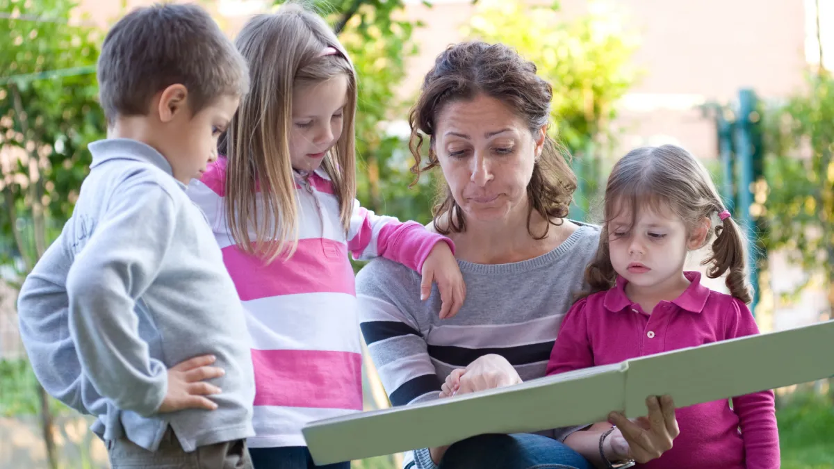 Image of mum with 3 children looking at a plan
