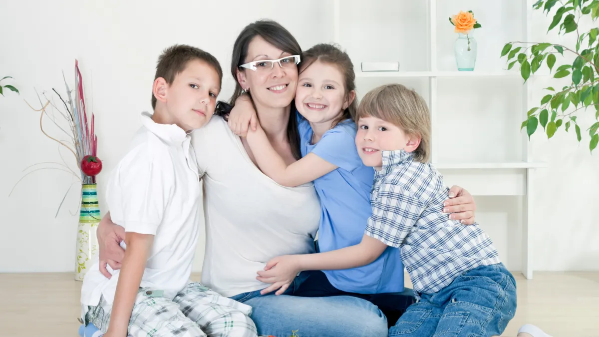 Mum of 3 cuddling them looking calm