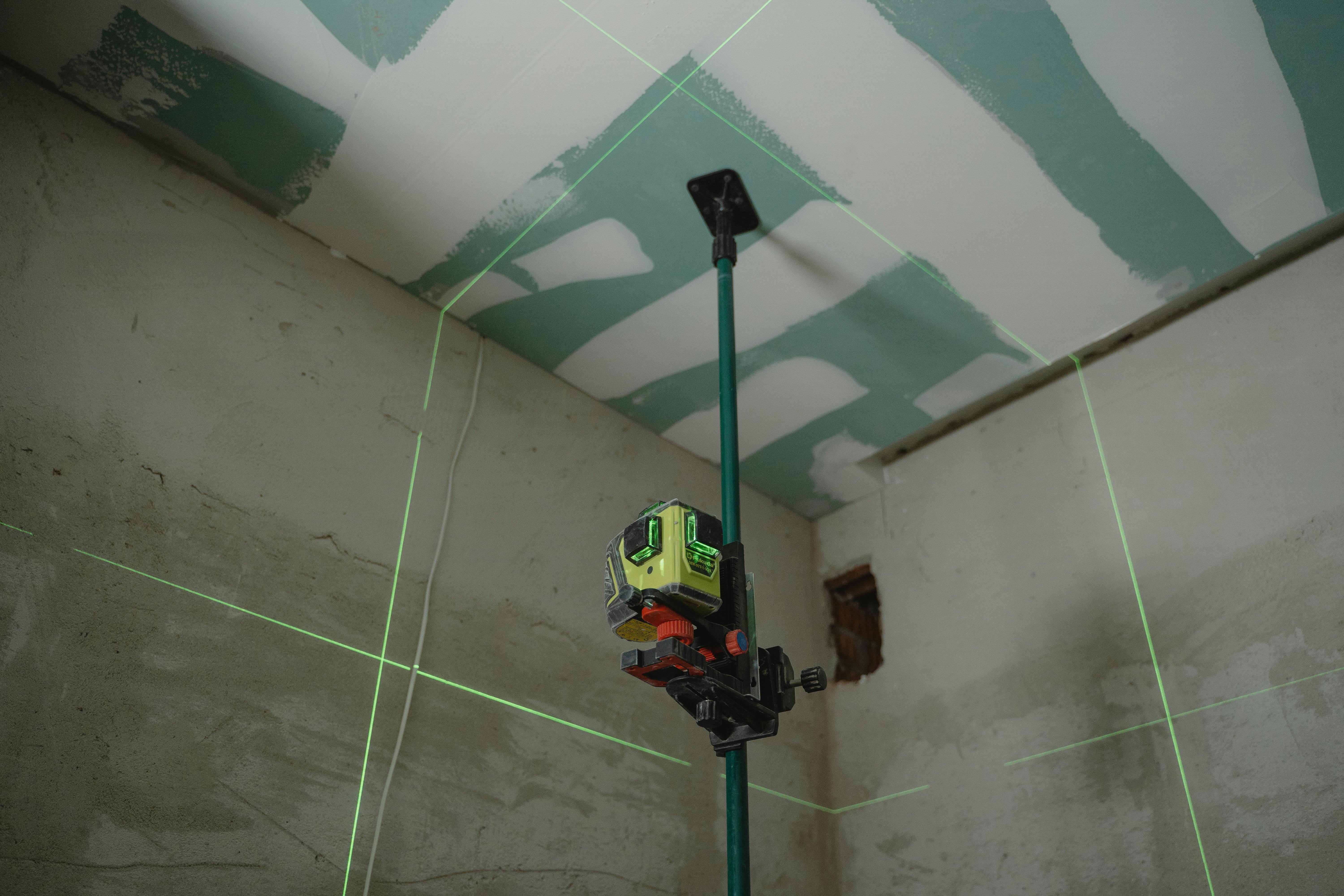 Image showing a laser level used to align ceiling drywall joints in a Memphis home affected by loess-soil settling and humidity-driven framing shifts. Demonstrates Local Handyman Midsouth’s precision approach to stabilizing ceilings in older Midtown and East Memphis houses.