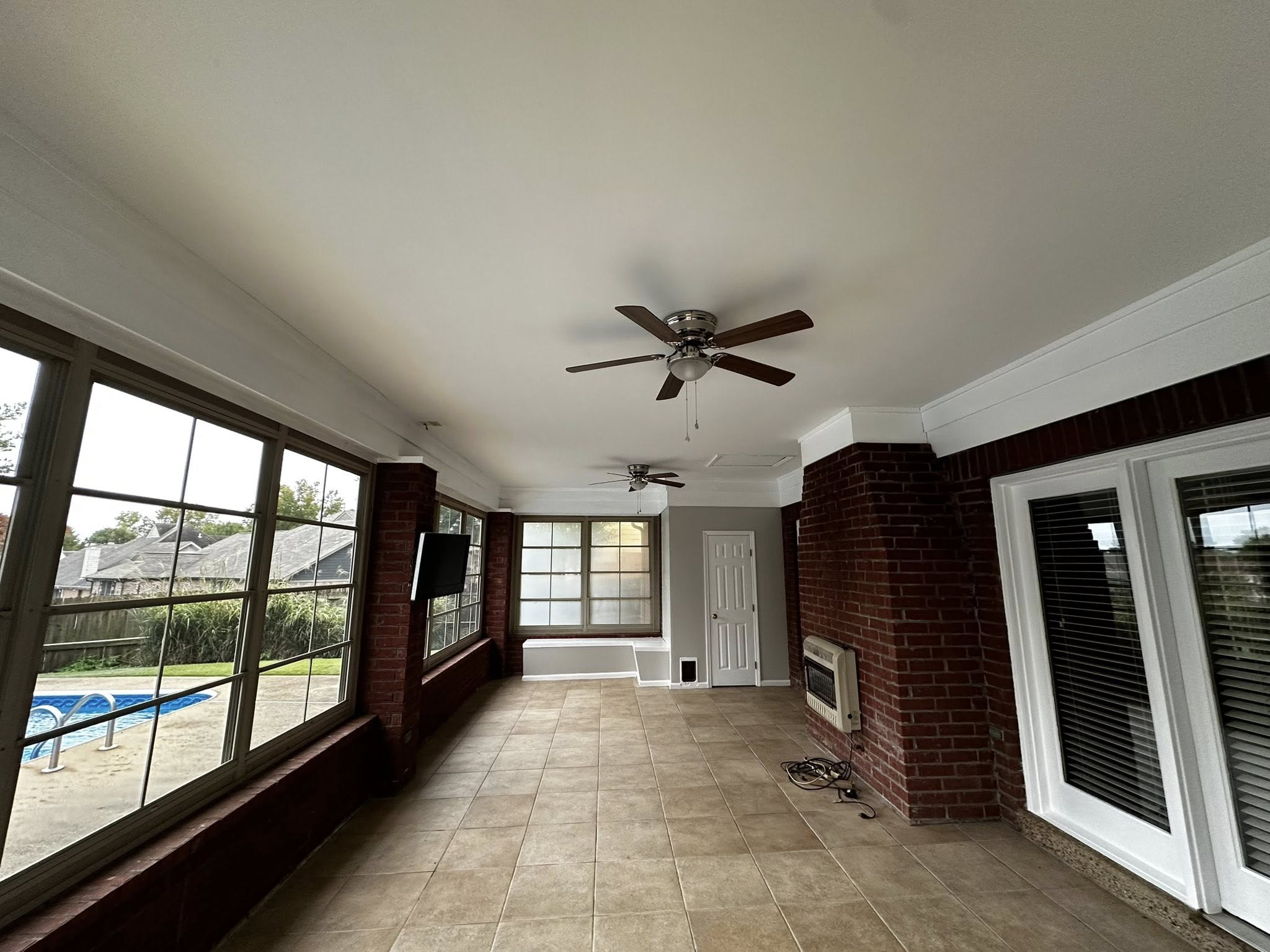 Clean, finished sunroom ceiling and window wall demonstrating the stable framing conditions needed before installing a storm door in Memphis, where humidity and loess-soil movement often push openings out of square. Shows the type of environment Local Handyman Midsouth prepares before hardware fitting.