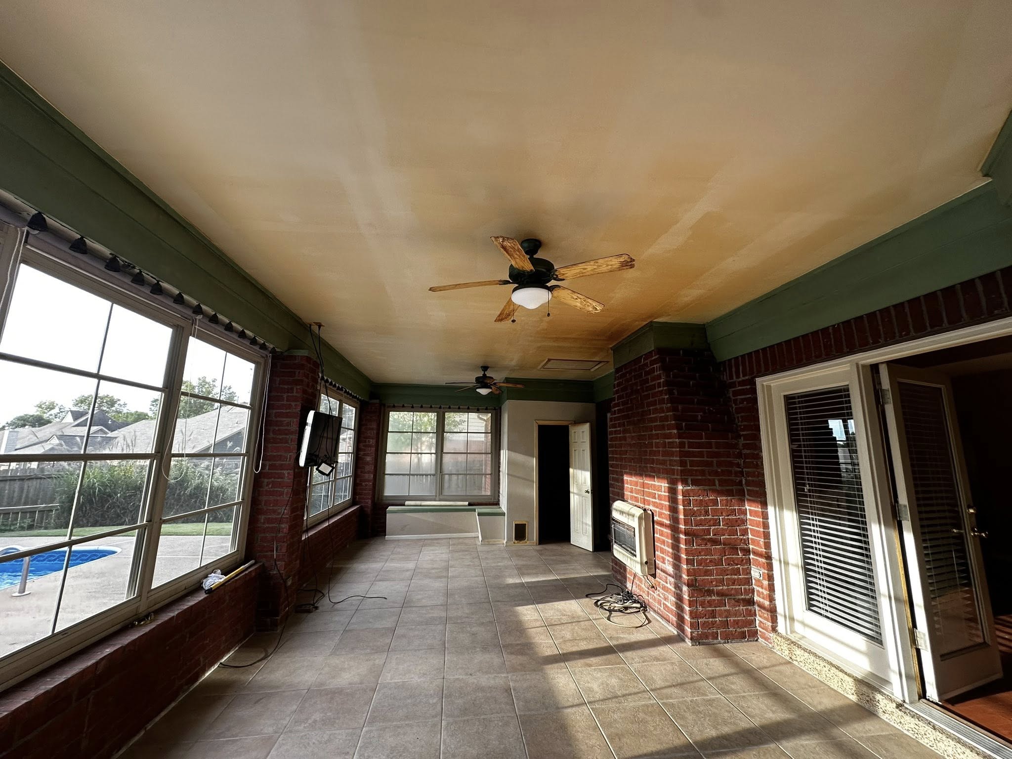 Before-condition image showing discoloration and humidity wear on a Memphis sunroom ceiling, highlighting how moisture swings and loess-soil movement affect trim and door-frame alignment before storm door installation. Reflects real local conditions Local Handyman Midsouth routinely stabilizes.
