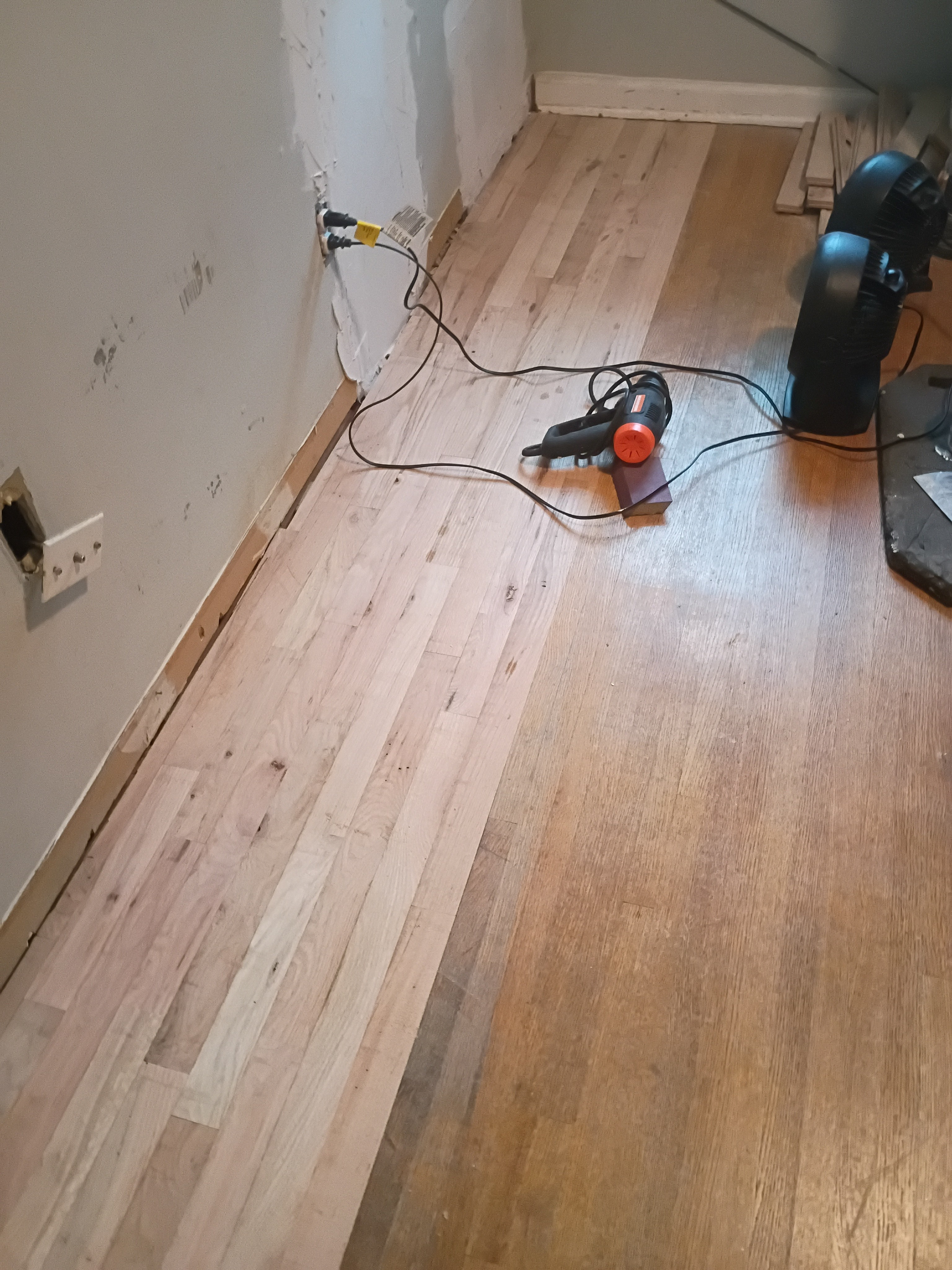Photo capturing unfinished hardwood sections and repair tools during a Memphis rental turnover, highlighting the moisture-driven cupping and traffic wear commonly found after move-outs. Reflects the practical refresh work Local Handyman Midsouth performs under tight timelines.