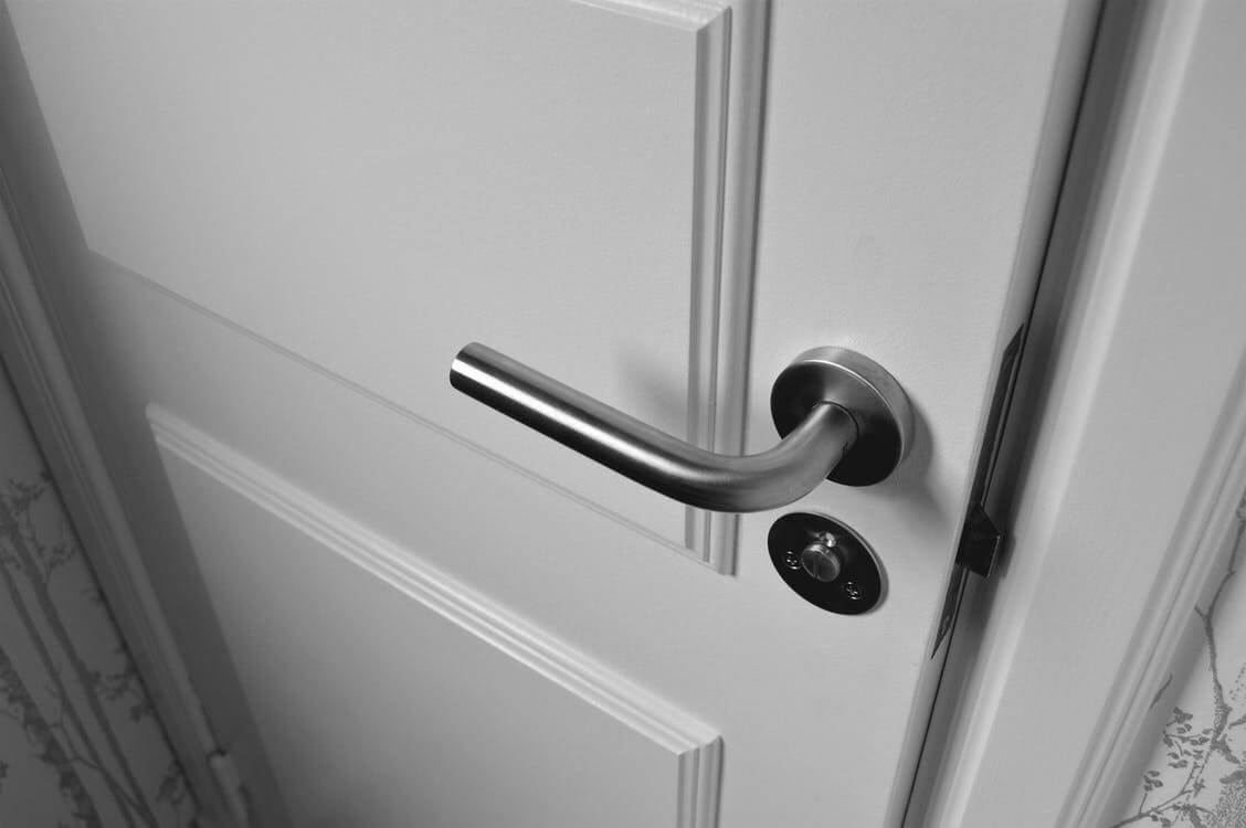 Close-up of a modern interior door handle and latch showing alignment issues requiring adjustment or repair.