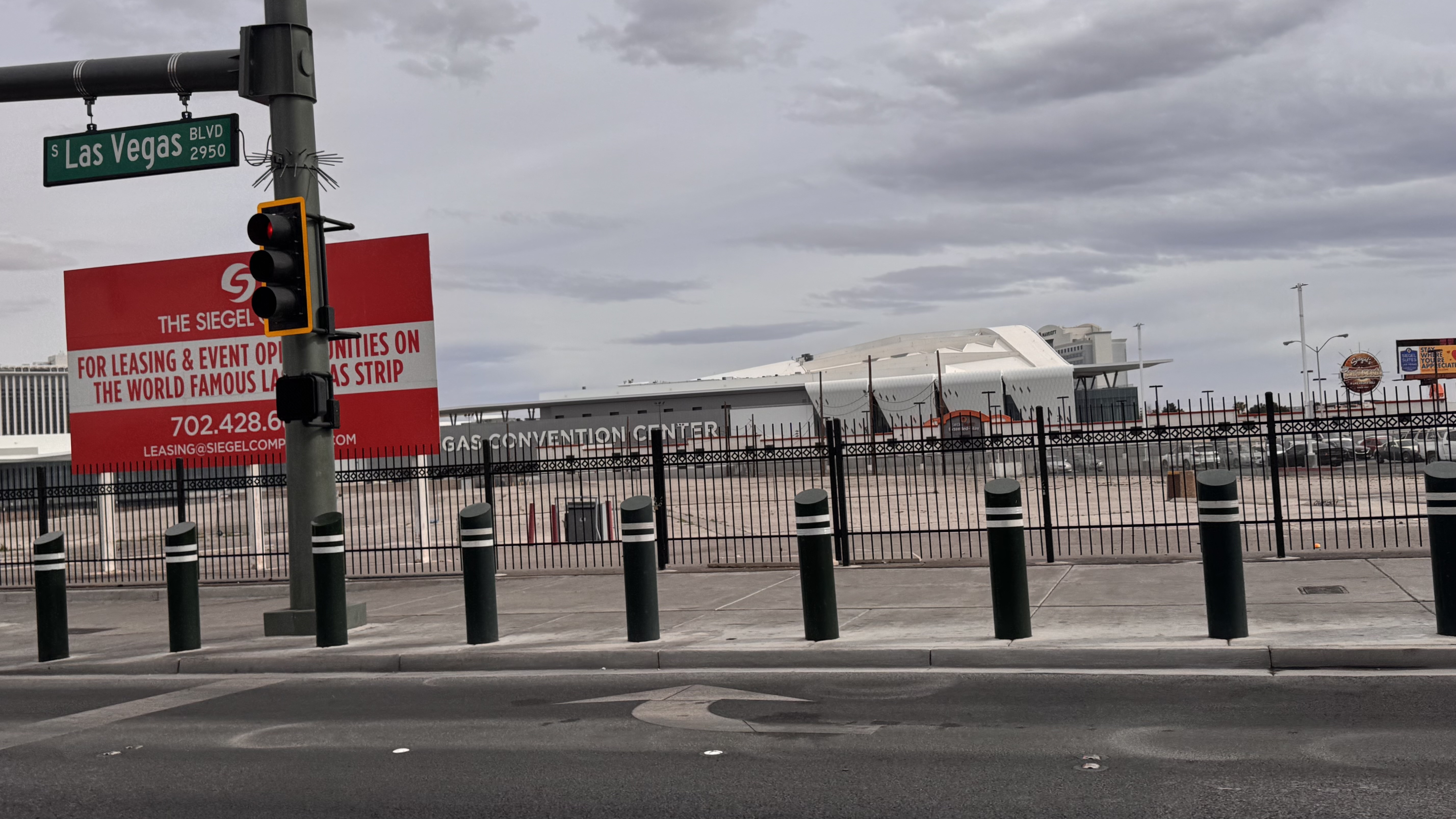 Las Vegas Blvd street scene showing traffic light, bollards, and the Las Vegas Convention Center in the background