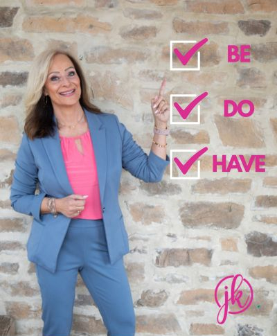 Julie K with the Be-Do-Have on a brick wall