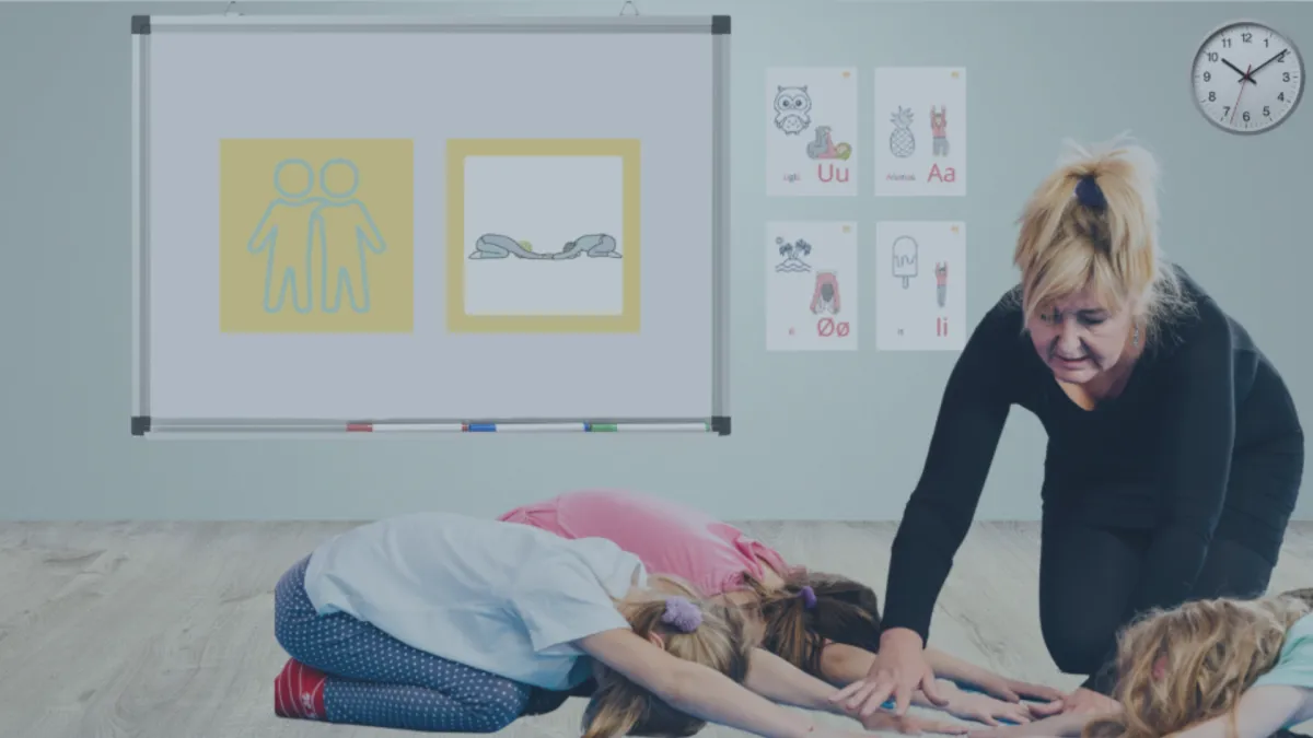 A laptop on a wooden desk displaying a live video call with a smiling instructor leading a yoga session. Next to the laptop are a notepad, pen, and a cup of herbal tea. The setting is cozy and organized, suggesting a comfortable home workspace for professional development.