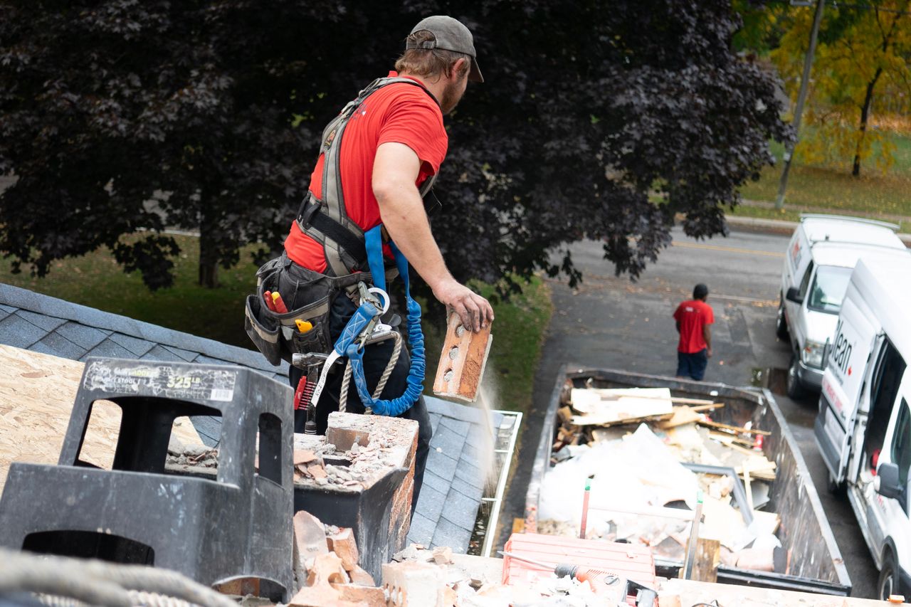 Contractor working on a roof with phone out of reach in truck below — illustrating the speed-to-lead gap in service businesses