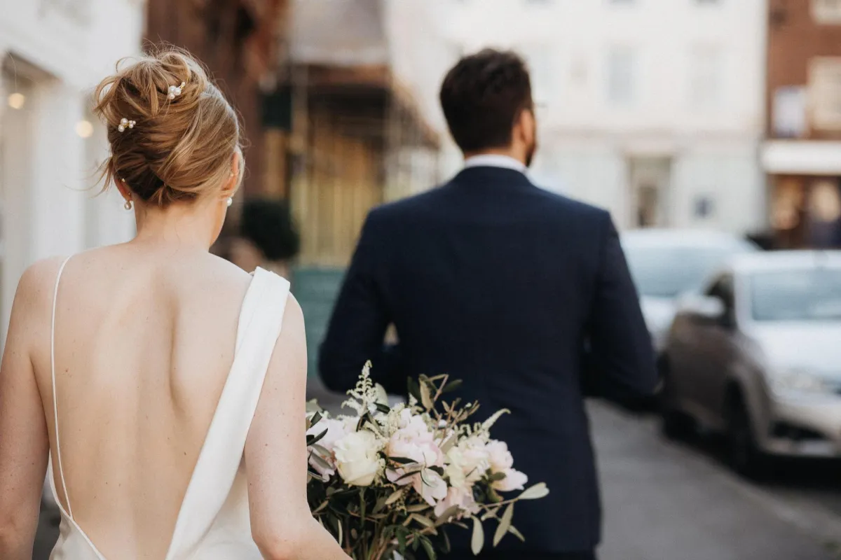Relaxed wedding photographer taking photo of wedding couple