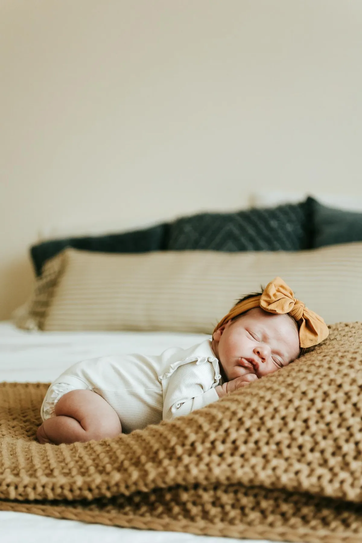 Photo of newborn baby sleeping on a bed in-home newborn photography in suffolk
