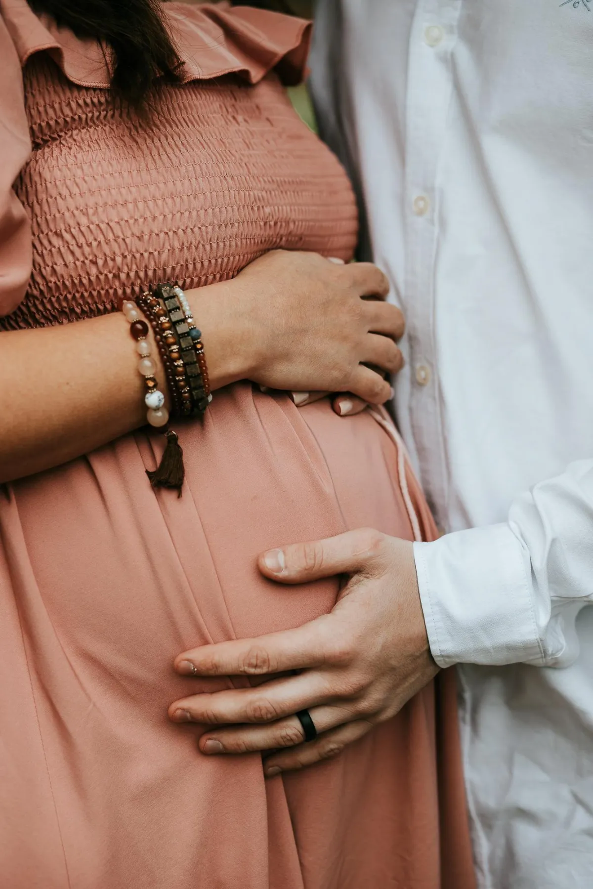 photo of couple holding pregnant belly during their maternity photoshoot in bury st edmunds