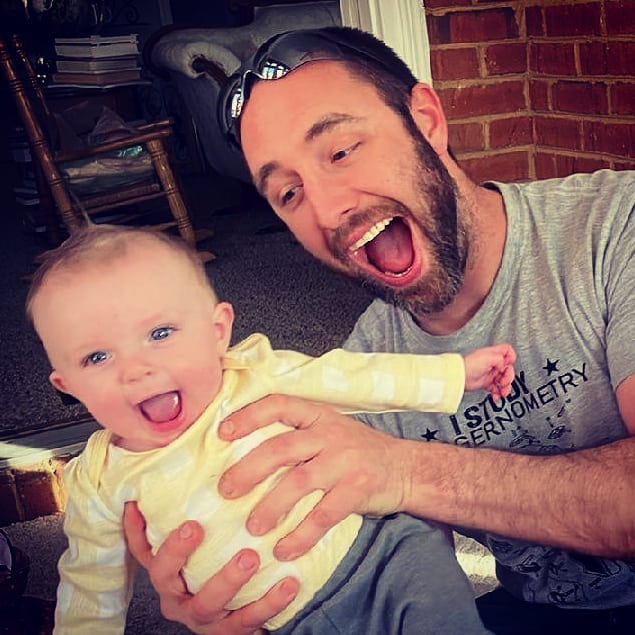 David Himes, co-owner and installer at NKY Kitchen Remodelers, holding his daughter and smiling.