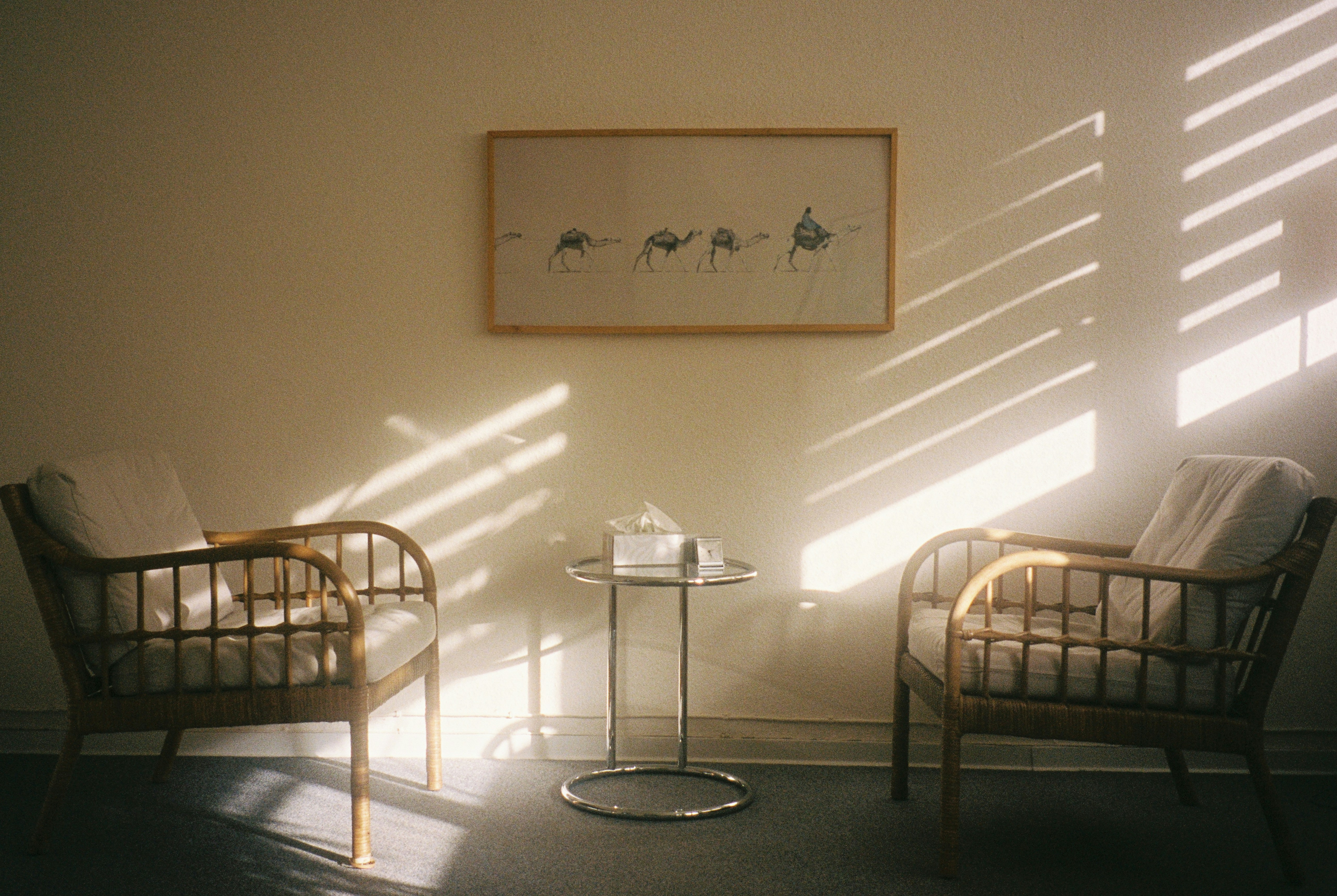 Two chairs facing each other next to a wall