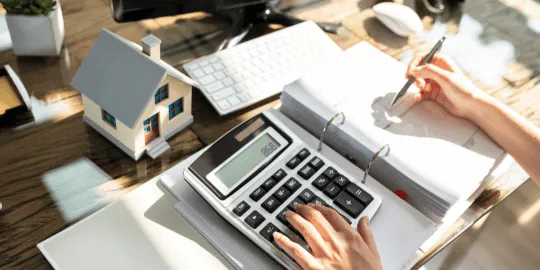 Person calculating IRS debt with tax lien documents on their desk