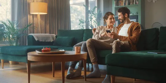 Couple on couch reading about IRS Tax Relief solutions a digital tablet