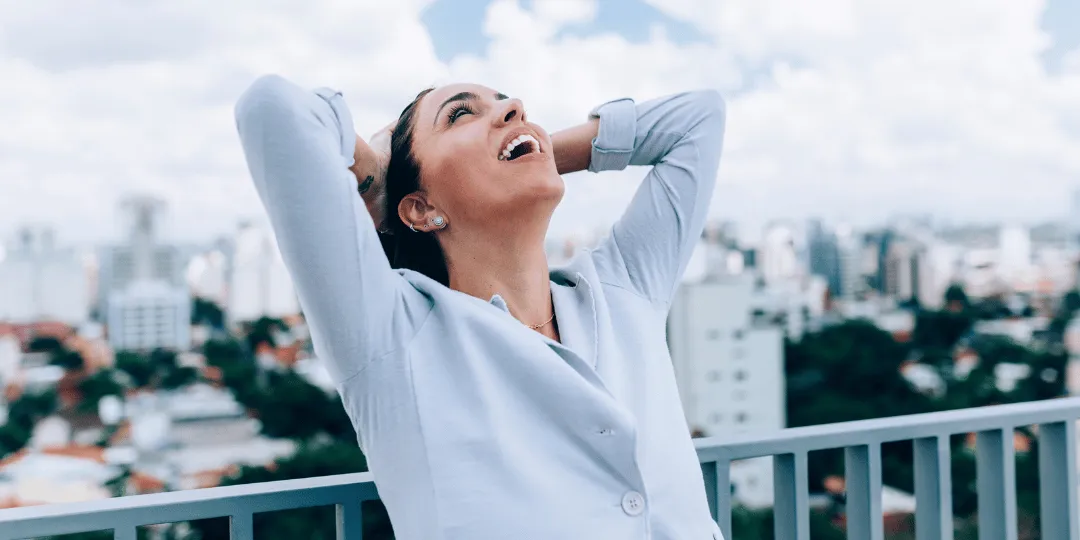 Woman smiling with arms raised in relief after resolving IRS financial hardship