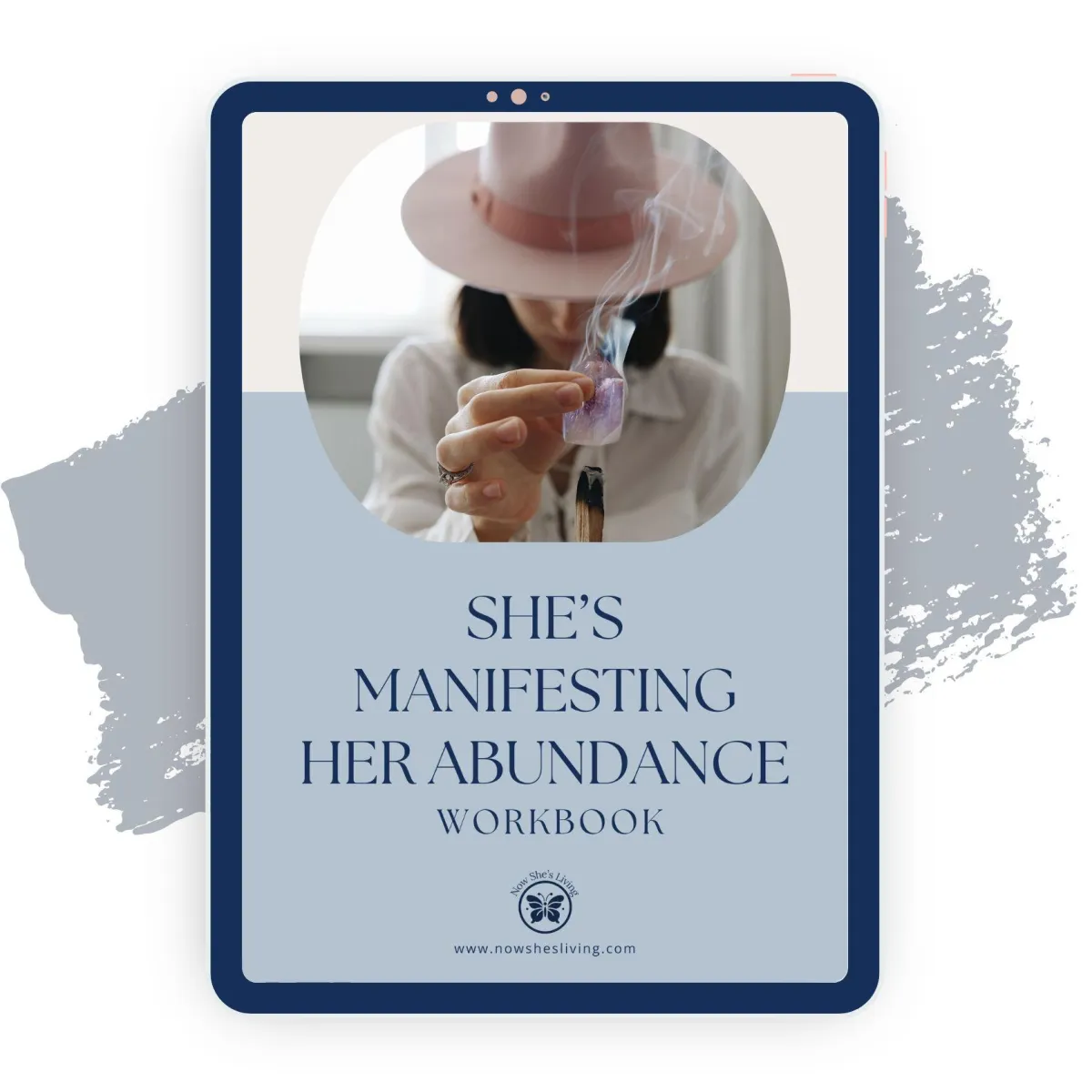 A woman wearing a wide-brimmed hat holds a piece of burning sage, releasing smoke as part of a manifestation ritual. The text on the cover reads 'She's Manifesting Her Abundance Workbook.' The Now She's Living logo and website link are displayed below