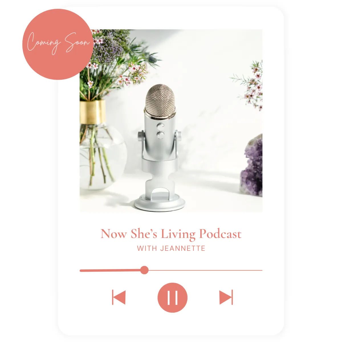 Elegant podcast setup featuring a silver microphone with a floral arrangement and amethyst crystals in the background. A soft and inviting design highlights the Now She’s Living Podcast with Jeannette, coming soon.