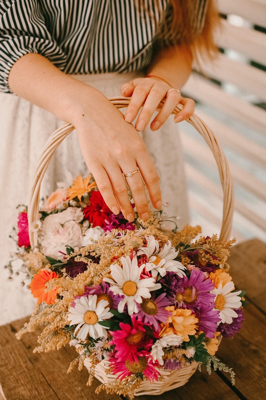 young woman hands holding a basket of flowers