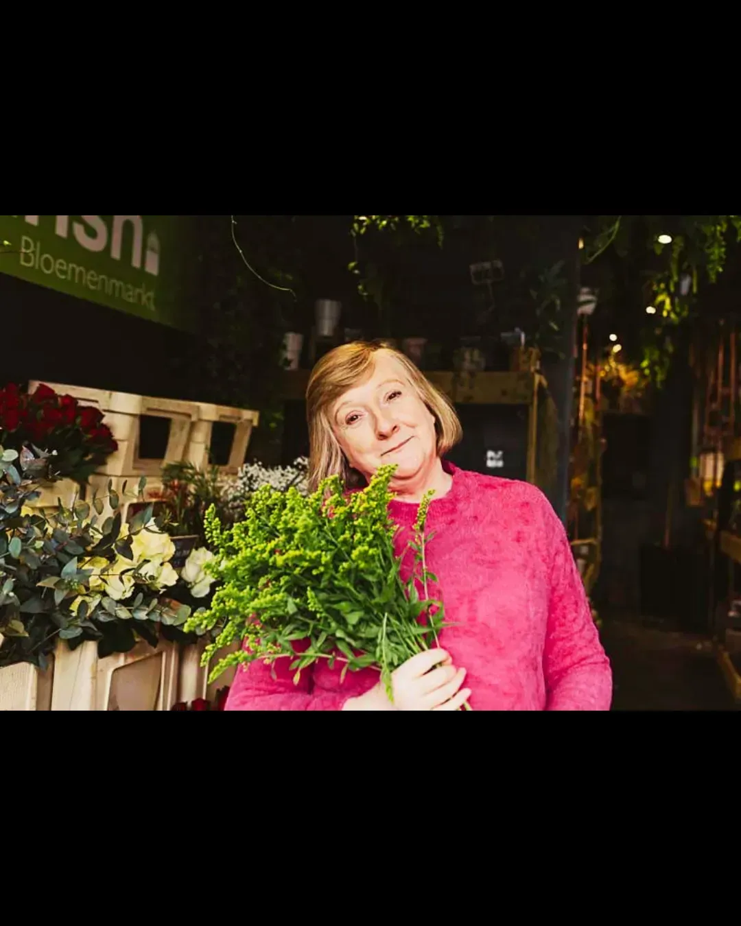 Marie Mulcahy, Medical Herbalist, holding a bunch of flowers