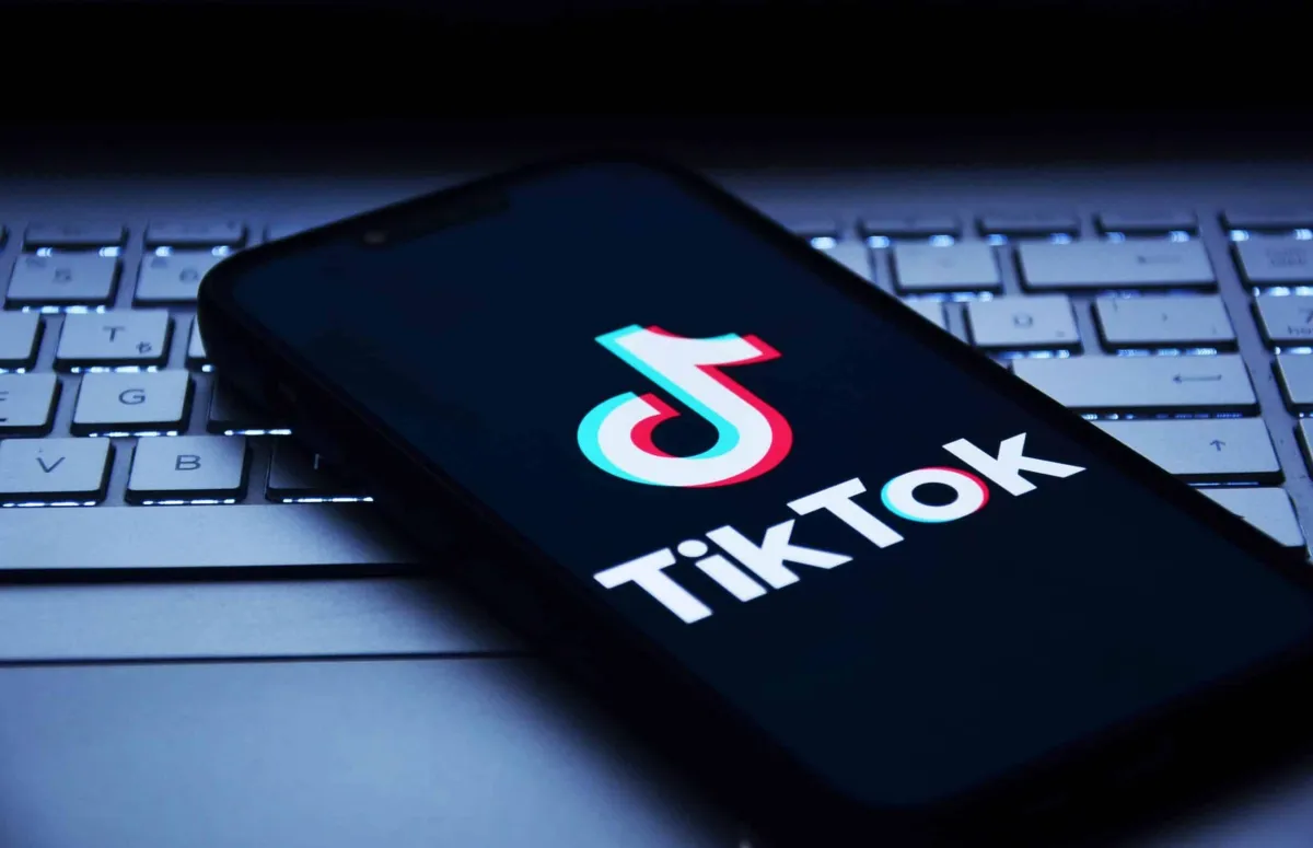 TikTok logo displayed on a smartphone screen resting on a laptop keyboard, symbolizing digital marketing and lead generation strategies for businesses.