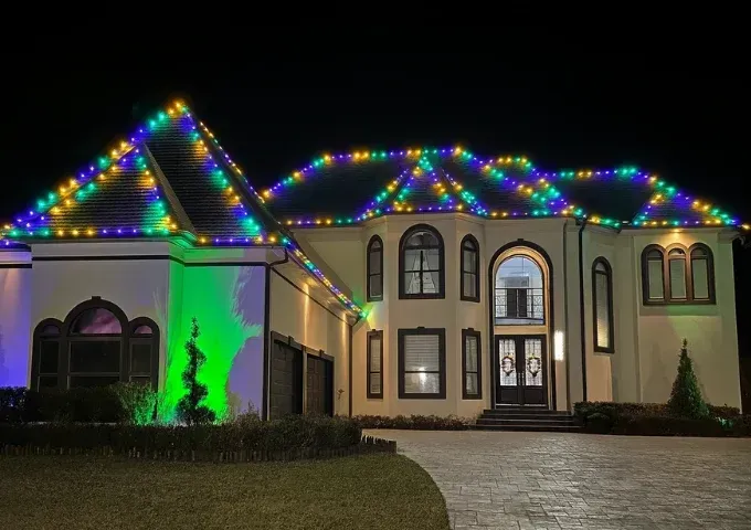 Residential Christmas lighting with trees and greenery