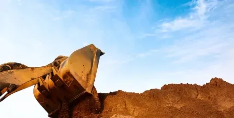 Excavator moving soil at a construction site for earthworks and land preparation