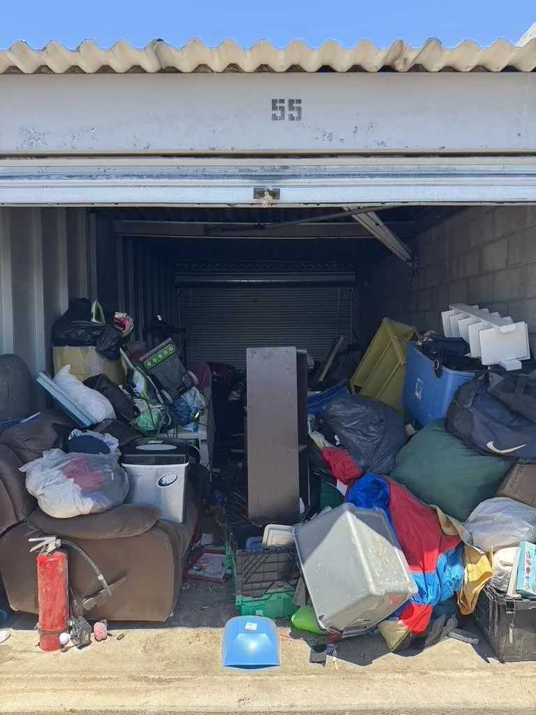 a pile of trash sitting next to a blue trash can