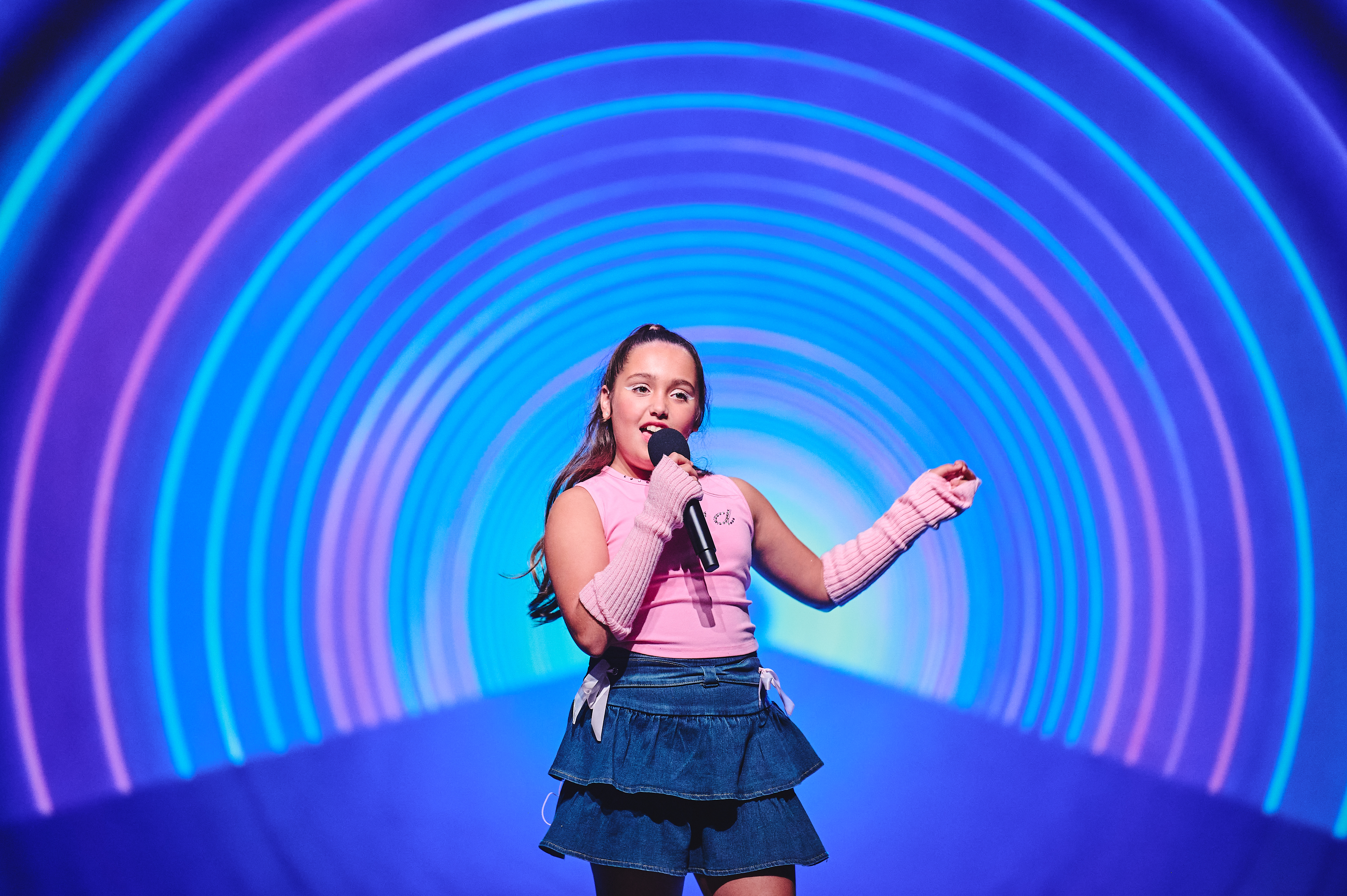 Teens performing a synchronized K-Pop dance routine in a high-tech studio